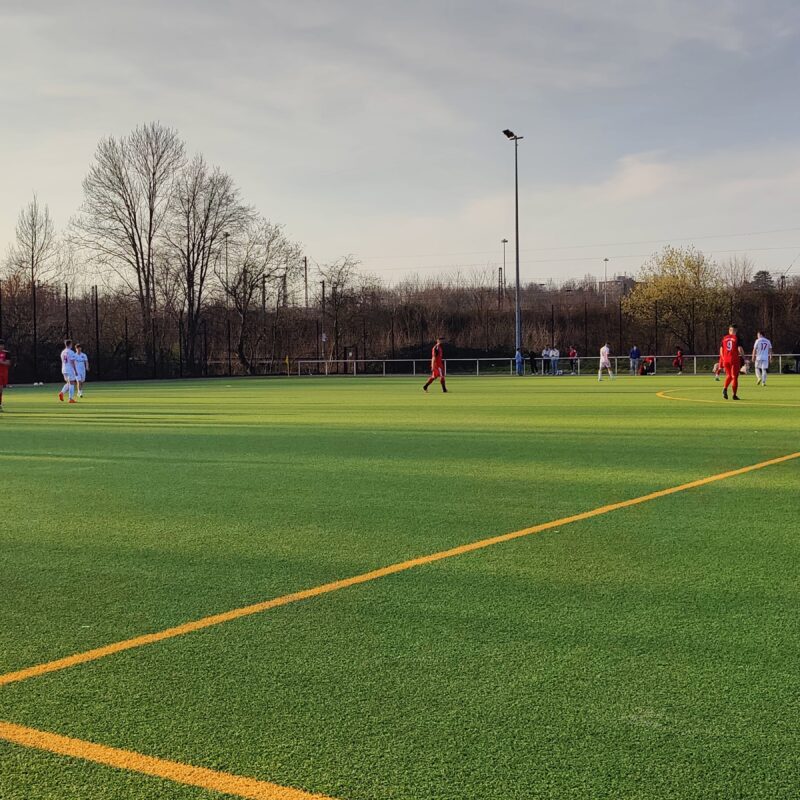 Kunstrasenspielfeld auf dem zwei Team gegeneinander Fußball spielen