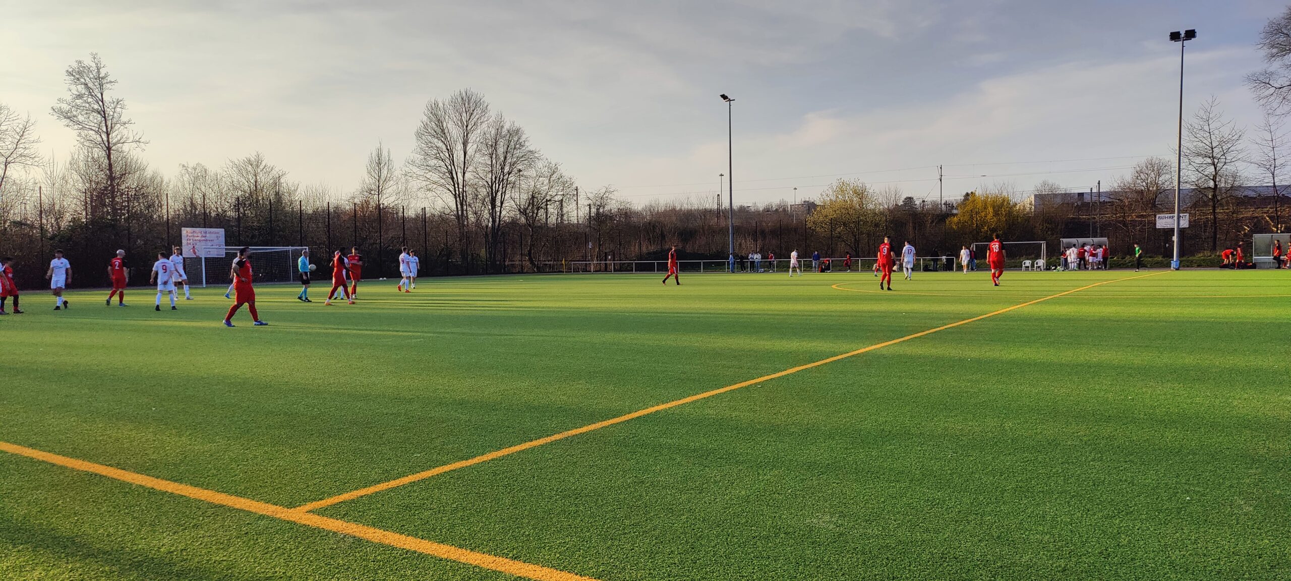 Kunstrasenspielfeld auf dem zwei Team gegeneinander Fußball spielen